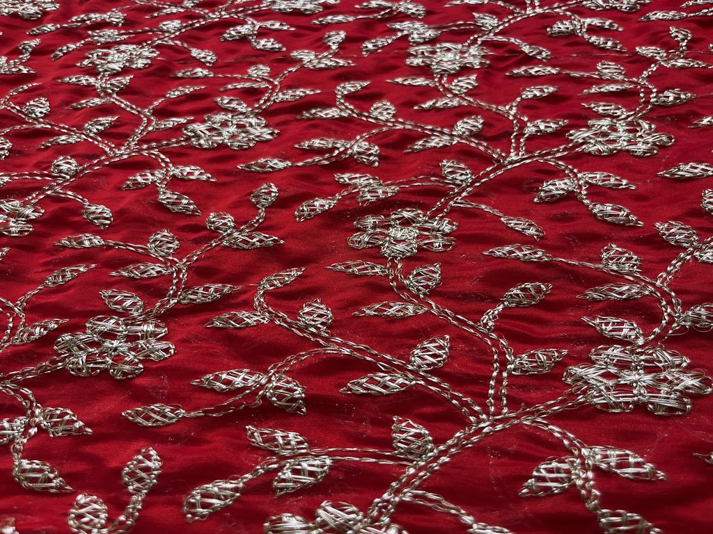 Zardozi embroidery with gold thread and embellishments on a red velvet fabric