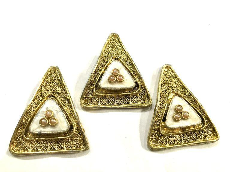 golden-triangular-metal-piece-with-white-enamel