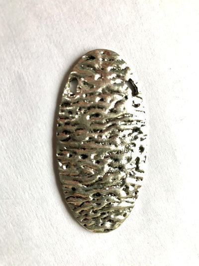 silver-oval-metal-piece-with-texture